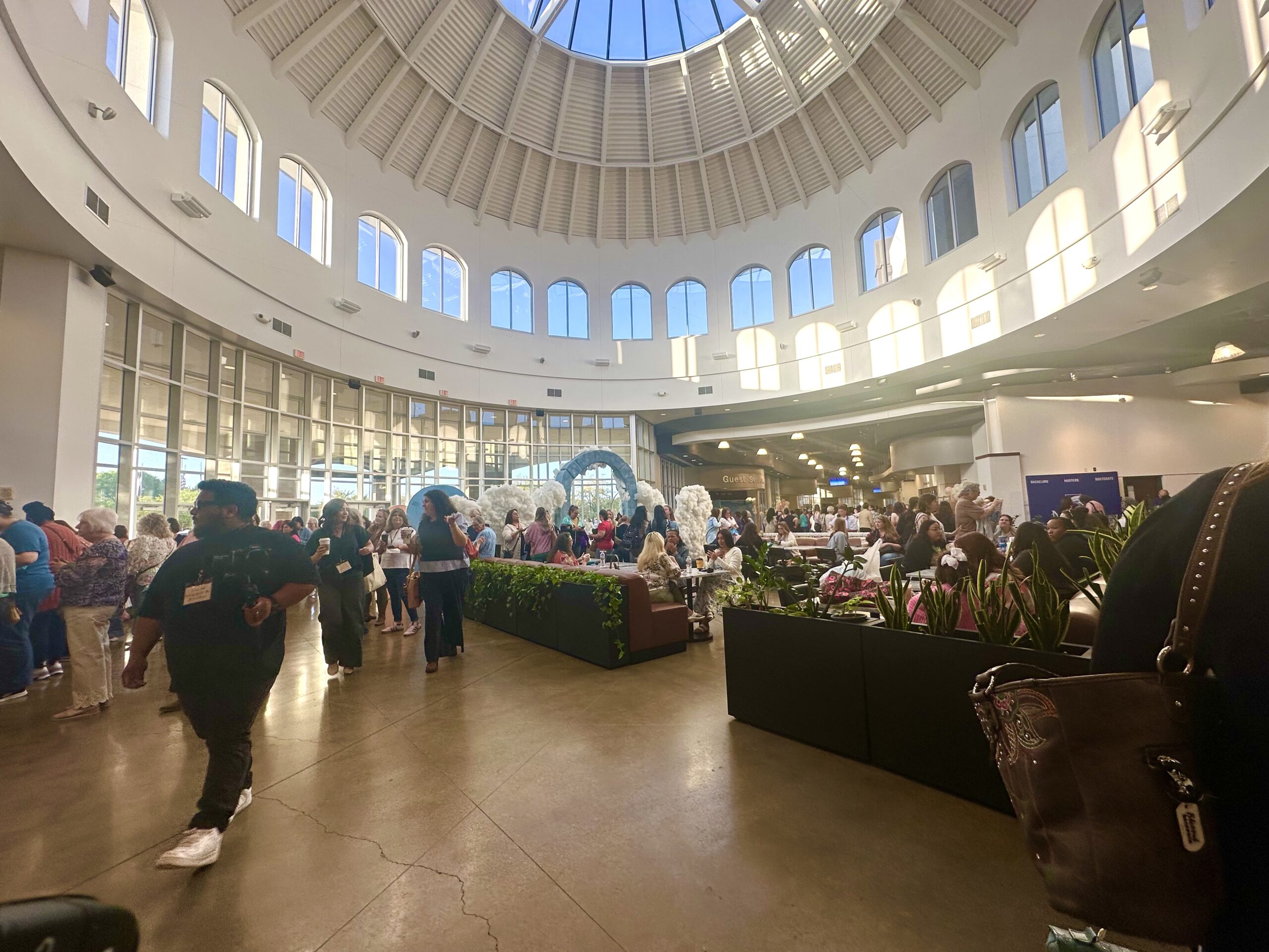 Women gathering in the lobby and fellowship area during the Bloom Conference in North Texas before conference sessions.