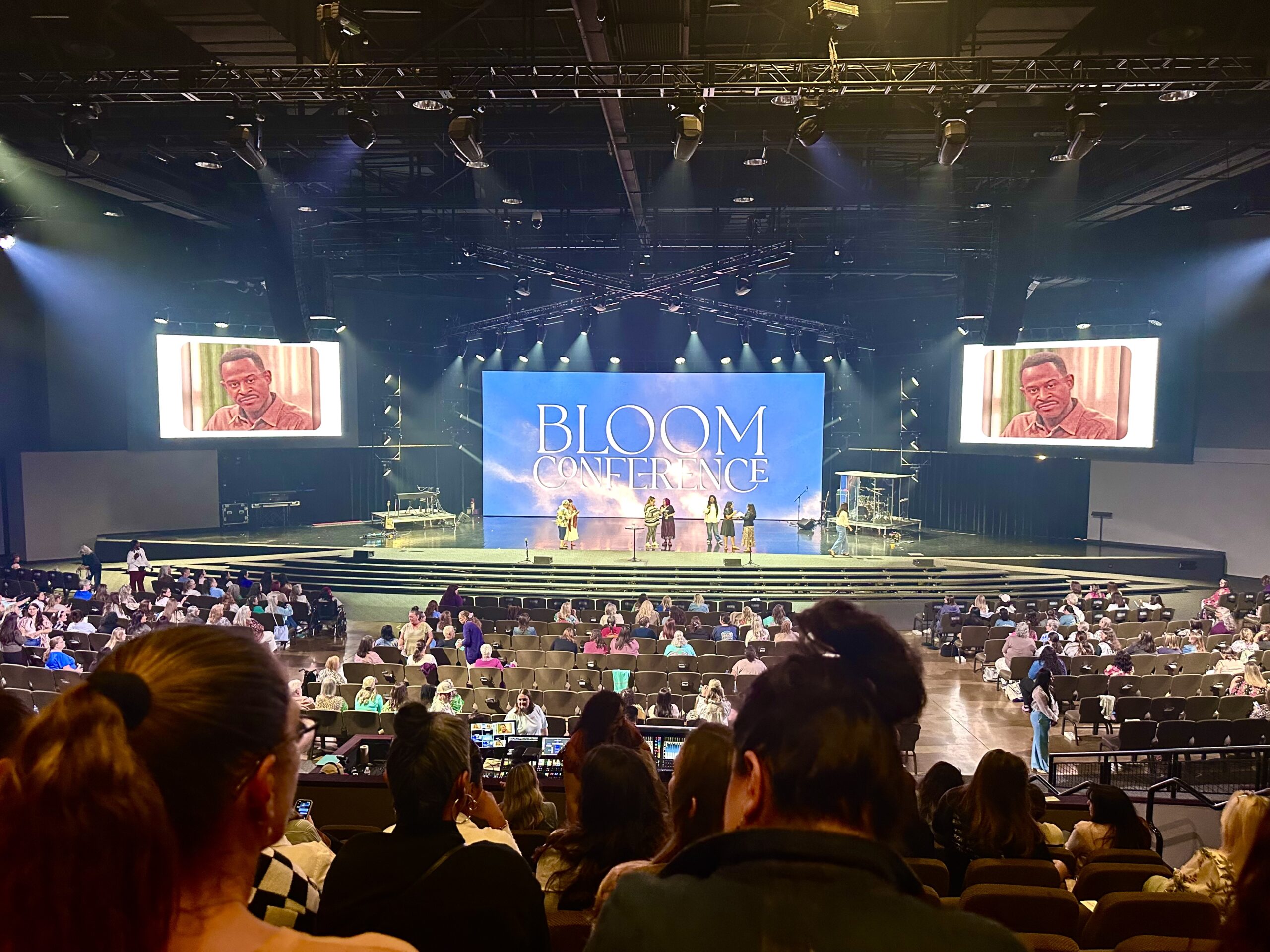 Women gathered inside the auditorium during a main session of the Bloom Conference in North Texas.