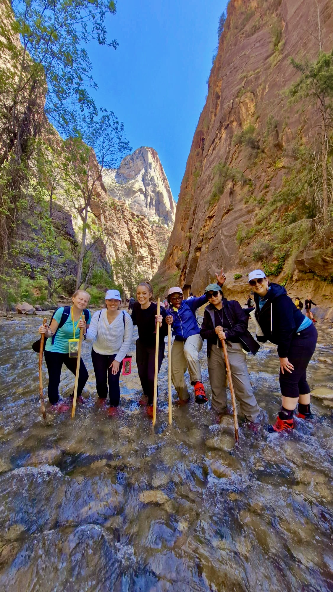 Group of women standing together in the Virgin River during The Narrows hike in Zion National Park.