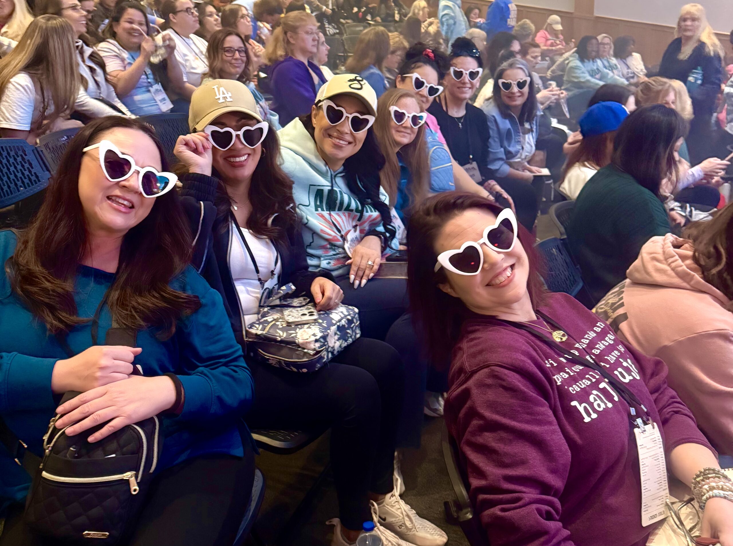 Friendships Formed at the Cornerstone Women's Retreat Group of women attending the Cornerstone Women's Retreat smiling and wearing matching heart-shaped sunglasses while gathered for a conference session in Williams, Arizona.
