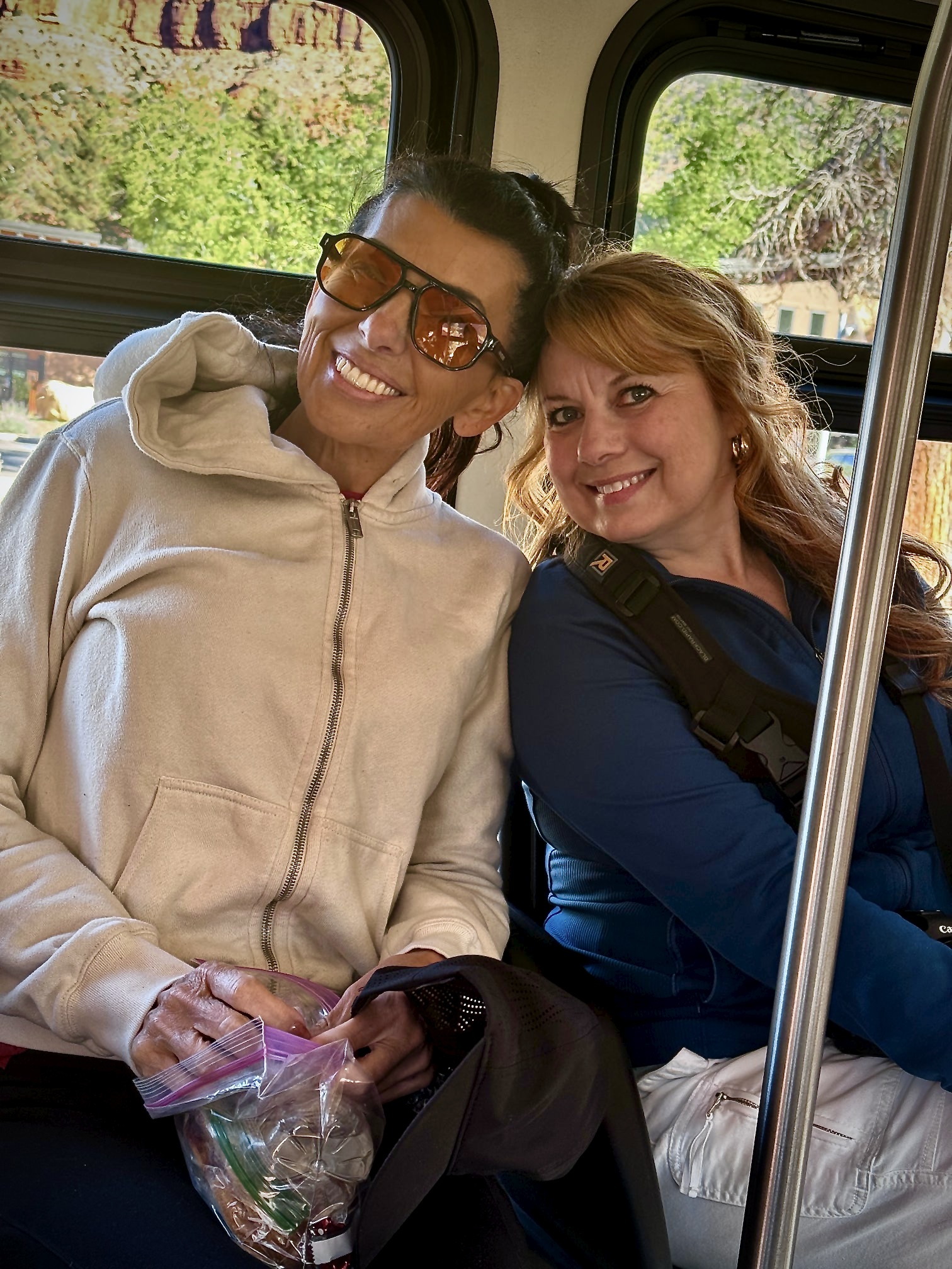 Two women smiling while riding the Zion National Park shuttle during the No More Dry Ground Retreat.